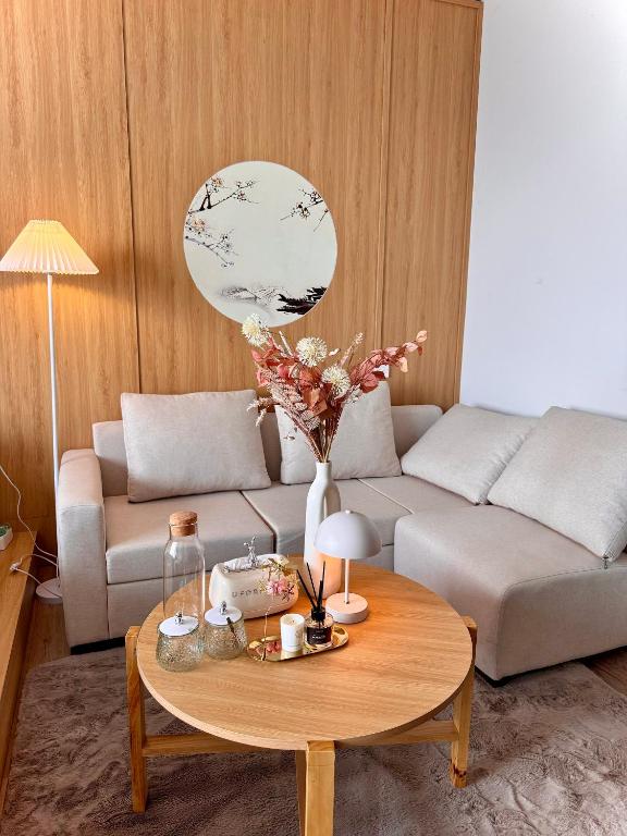 a living room with a couch and a coffee table at Onsen Landmark Ecopark in Cong Luận