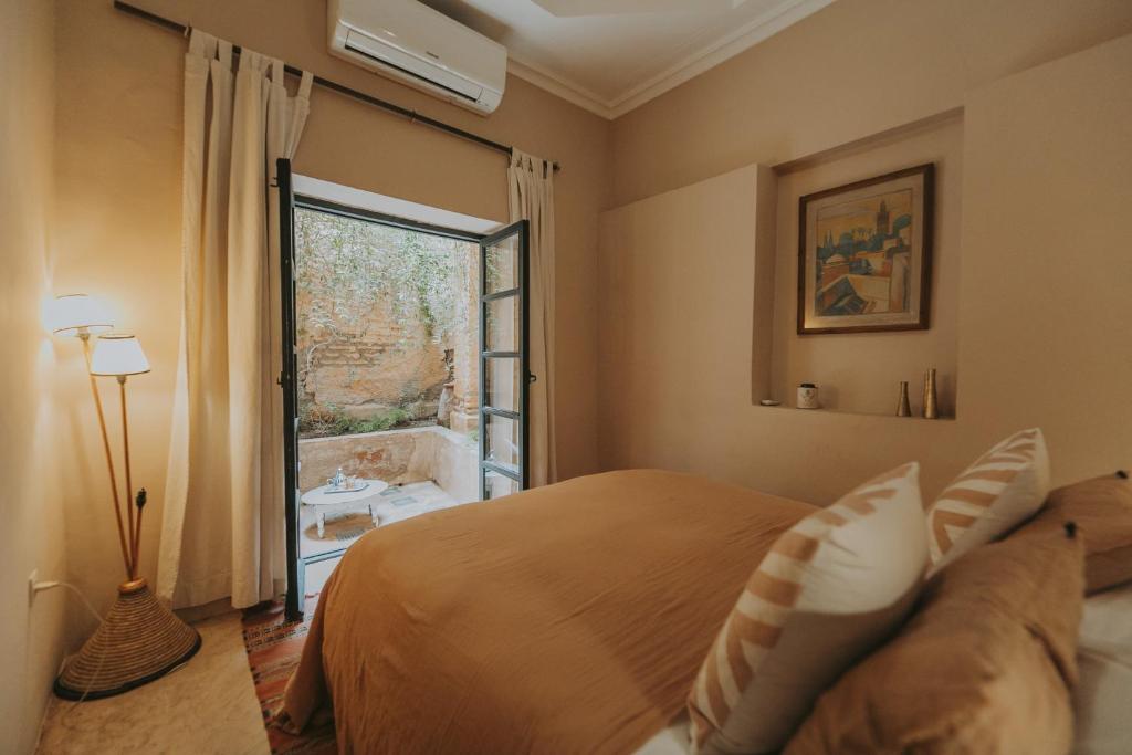 a bedroom with a bed and a large window at Dar El Qadi in Marrakech