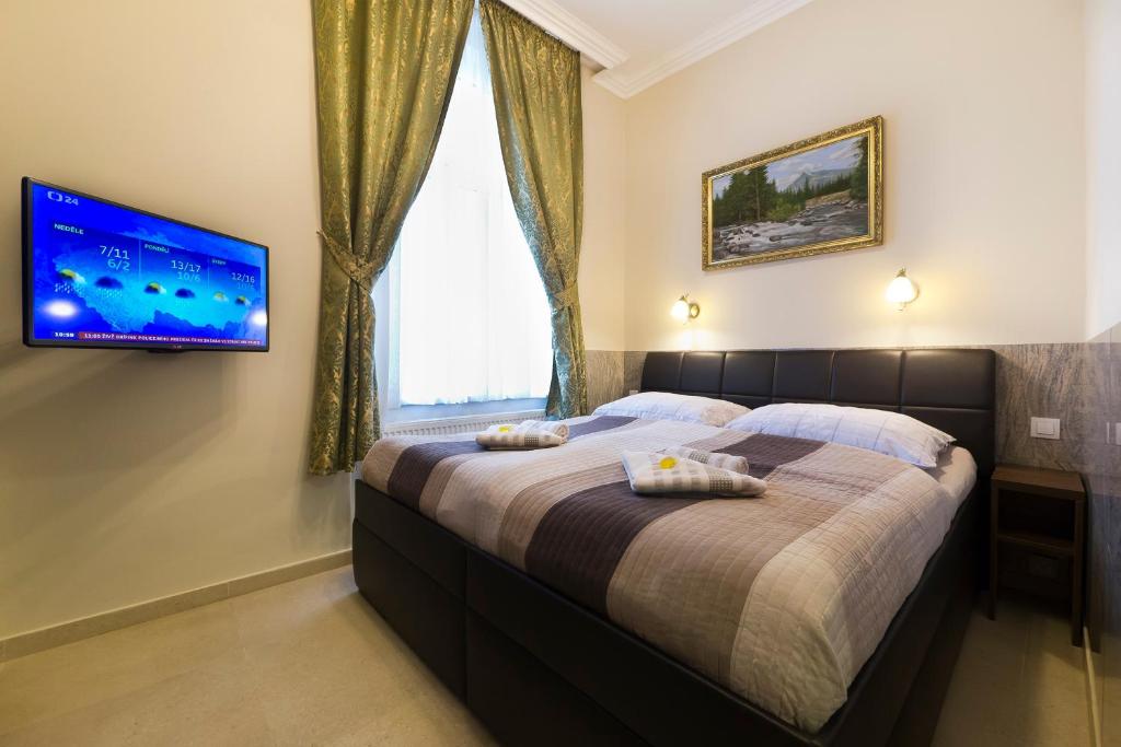 a bedroom with a large bed with a tv on the wall at Apartment Karla Capka Street in Karlovy Vary