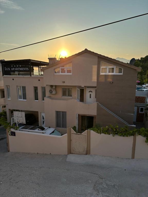 a building with the sun setting on top of it at ID apartments in Tivat