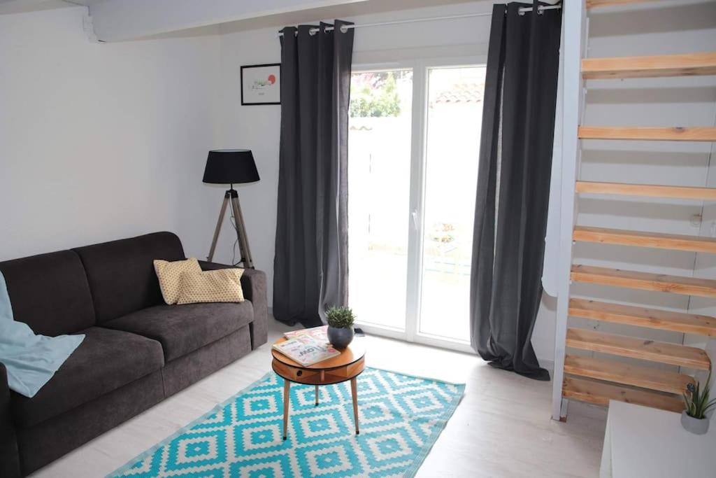 un salon avec un canapé et une table dans l'établissement A deux pas de la plage - Les lauriers roses, à Saint-Georges-de-Didonne