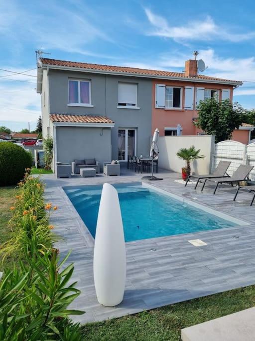 - une piscine avec une planche de surf à côté d'une maison dans l'établissement Agréable maison de ville avec piscine, à La Teste-de-Buch