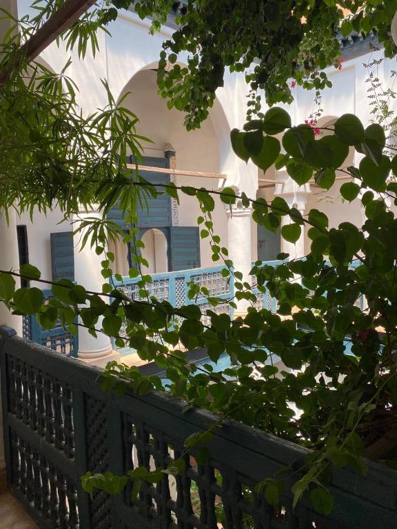 a white building with blue shutters and a fence at Dar El Qadi in Marrakech