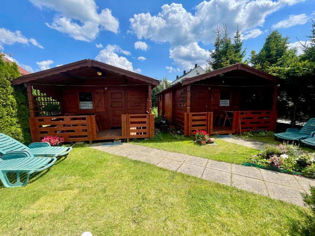 a couple of huts in a yard with chairs at Domki u Haliny in Przewłoka