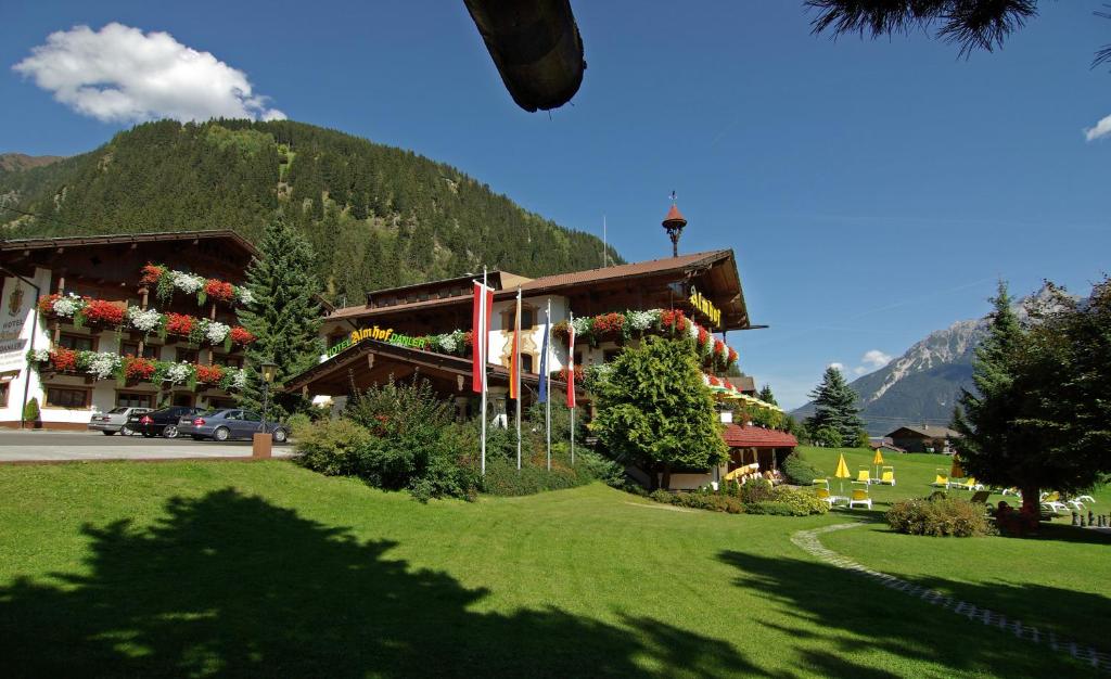 a building with flowers on the front and a mountain at Hotel Almhof in Neustift im Stubaital