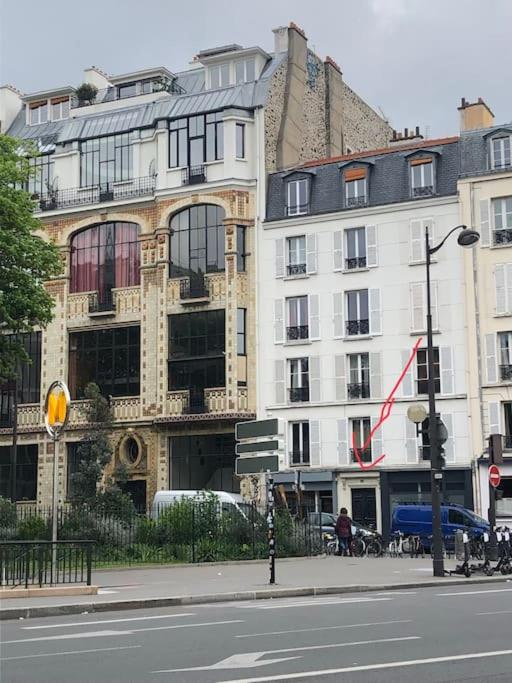 un bâtiment au bord d'une rue de la ville dans l'établissement Charmant duplex Metro Raspail jardin du Luxembourg, à Paris