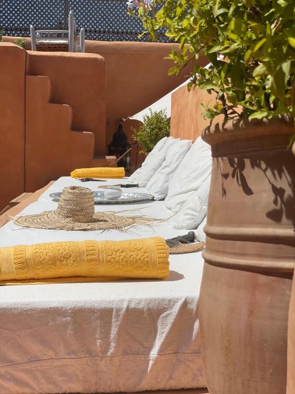 a bed with two pillows and a plant on it at Dar El Qadi in Marrakech