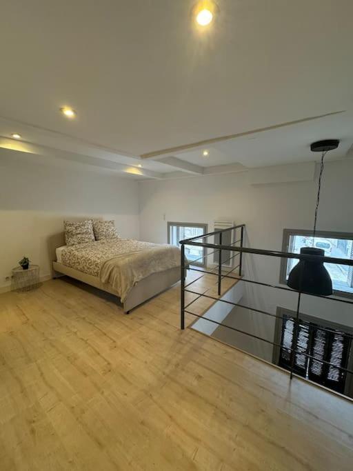 - une grande chambre avec un lit et du parquet dans l'établissement Charmant et spacieux duplex rue Paradis, Marseille, à Marseille