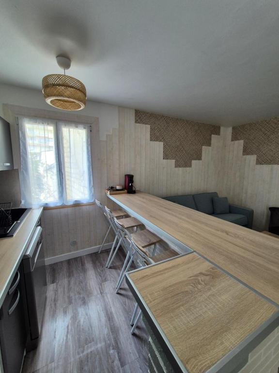 - une cuisine avec une grande table en bois dans l'établissement Bel appartement proche Paris, à Puteaux