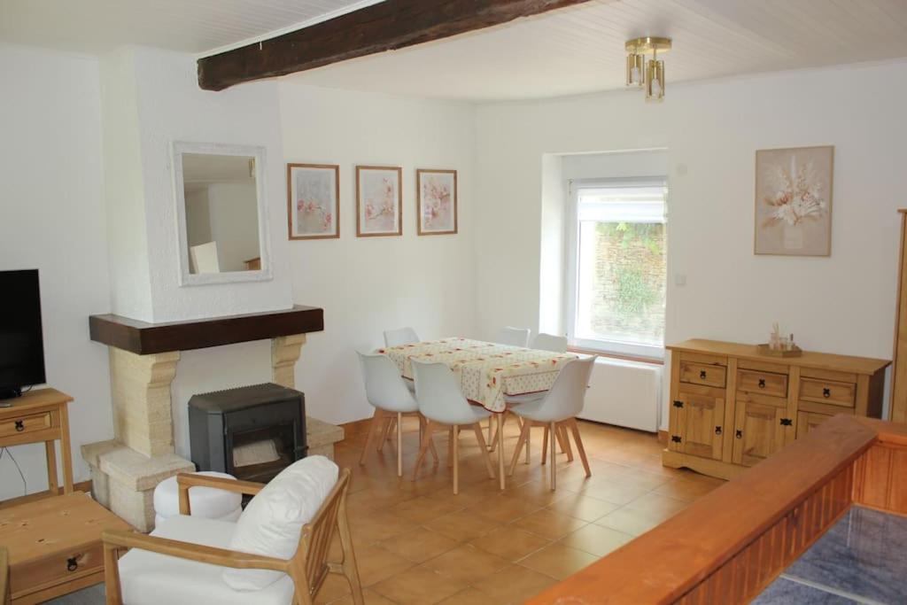 un salon avec une table et une cheminée dans l'établissement La Maison Fleurie, à Josselin