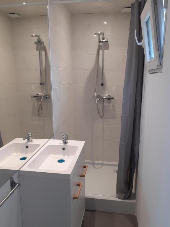 une salle de bain avec deux lavabos et une douche dans l'établissement Le petit Gîte de France, à Libourne