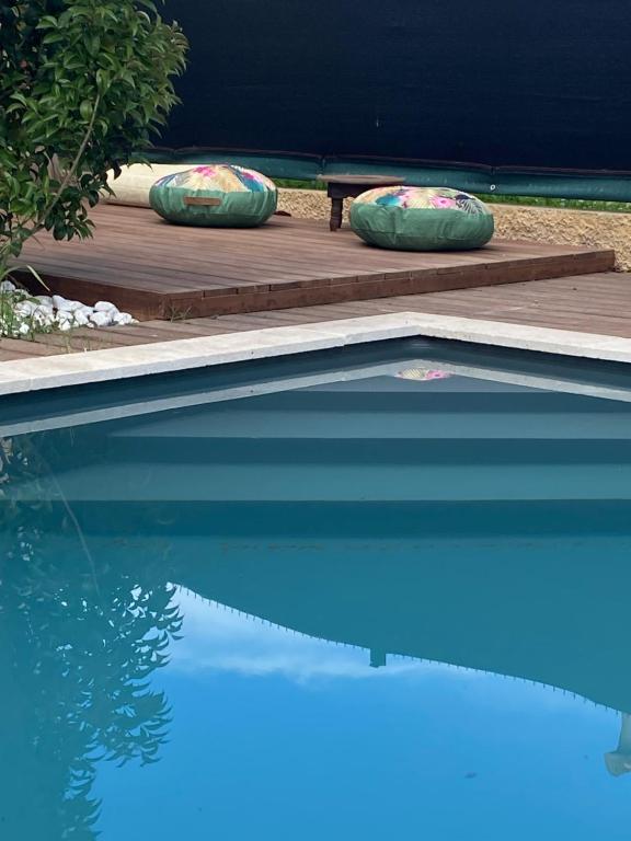 - une piscine avec des oreillers sur une terrasse en bois dans l'établissement Villa cosy pour 8 Pers avec piscine, dentelles de Montmirail, Ventoux Provence, à Aubignan