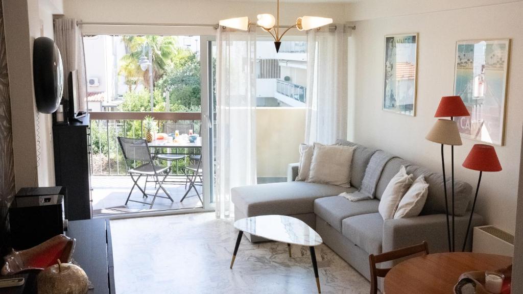 un salon avec un canapé et une table dans l'établissement Charmant et cosy, à 100m de la plage avec terrasse, à Cannes
