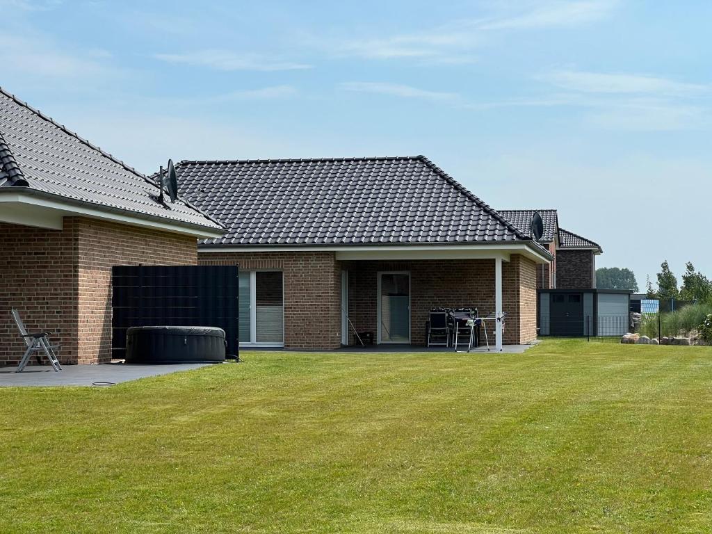 a brick house with a lawn in front of it at Ferienhaus RELAX in Büsum
