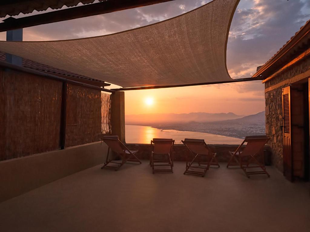 a balcony with chairs and a view of the ocean at Villa Oraia Verga Kalamata in Kalamata