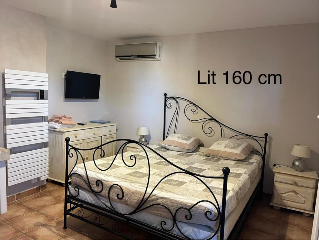 ein Schlafzimmer mit einem Bett und einem Aufzugsschild an der Wand in der Unterkunft Logement indépendant Au Bonheur cuisine piscine clim proche centre village #dentelles Montmirrail in Beaumes-de-Venise