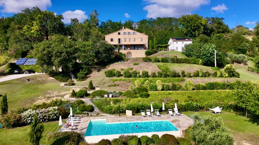 an estate with a swimming pool on a hill with a house at La Giravolta Country House in Barchi