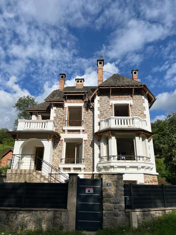 une ancienne maison en pierre avec une clôture devant elle dans l'établissement Au calme, à Saint-Sylvain