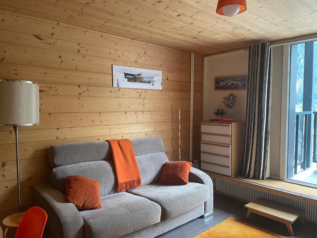 un salon avec un canapé et une fenêtre dans l'établissement Plein centre vue panoramique exceptionnelle Sud très grand studio, à Chamonix-Mont-Blanc