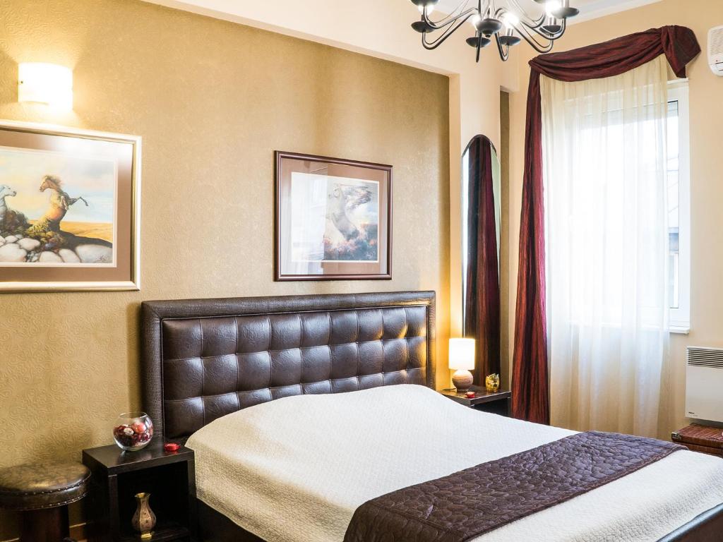 a bedroom with a bed and a chandelier at Verdi Apartment in Belgrade