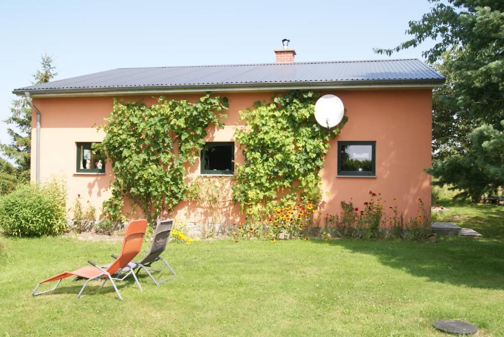 zwei Stühle im Hof eines Hauses in der Unterkunft Ferienhaus Bartelshagen 1 in Marlow