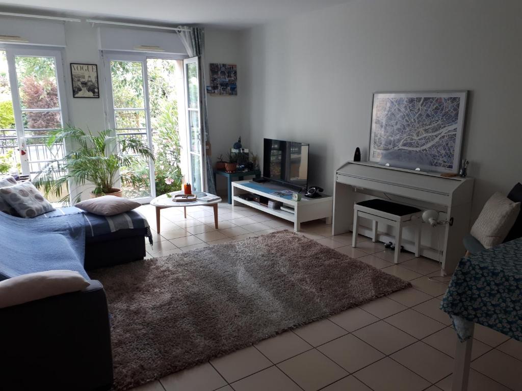 - un salon avec un canapé et un piano dans l'établissement Appartement Le Plessis-Robinson, au Plessis-Robinson