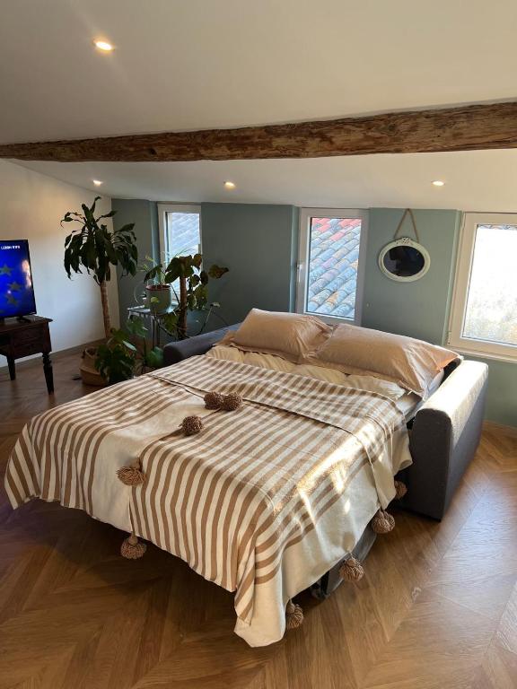 - un grand lit avec une couverture rayée dans une chambre dans l'établissement Chez Eric et Jess, à Narbonne