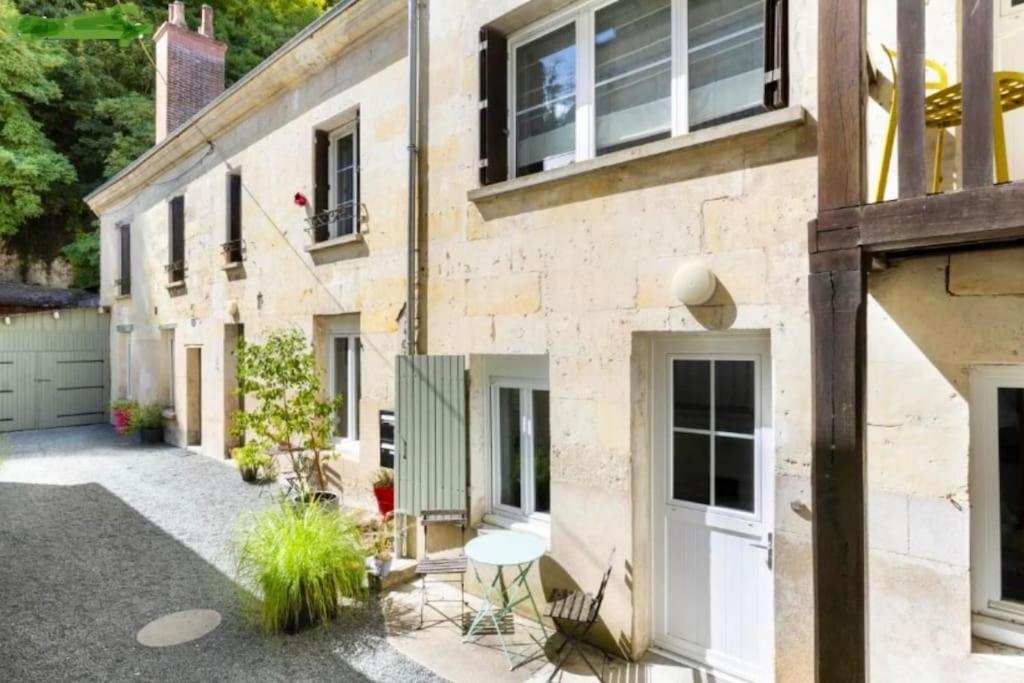 Elle offre une vue sur l'extérieur d'une maison en briques dotée d'une terrasse. dans l'établissement Logement La chartre sur le Loir 75m2, à La Chartre-sur-le-Loir