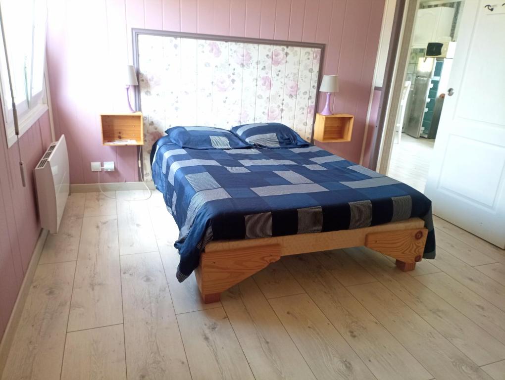 une chambre avec un lit avec une couette bleue et blanche dans l'établissement Petite maison toute équipée, au calme entre la mer et la campagne, à Fresney-le-Puceux