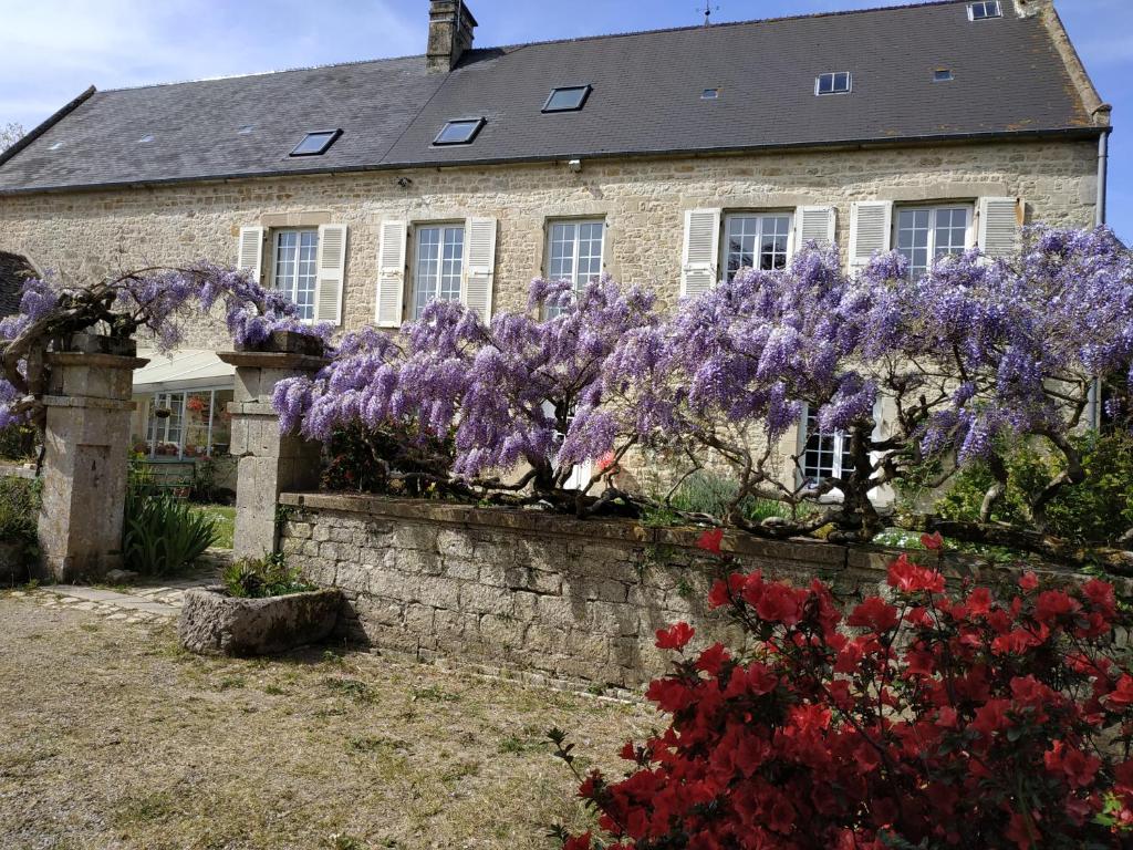 a house with purple wisteria in front of it at maison familiale au cœur du cotentin in Valognes