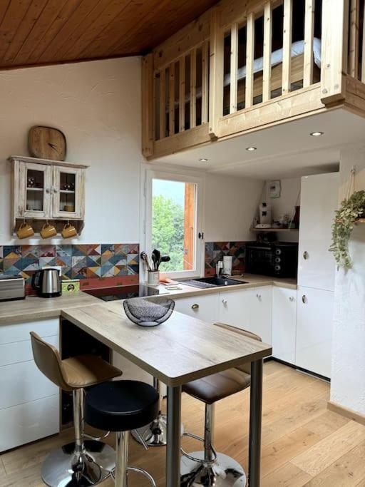 une cuisine avec une table et quelques chaises dans l'établissement Le Cozet, à Saint-Gervais-les-Bains