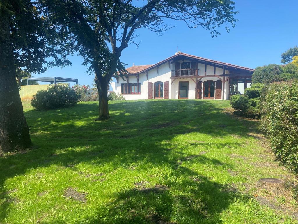 une vieille maison avec un arbre dans la cour dans l'établissement VILLA DOMAINE du DOUC, à Liposthey