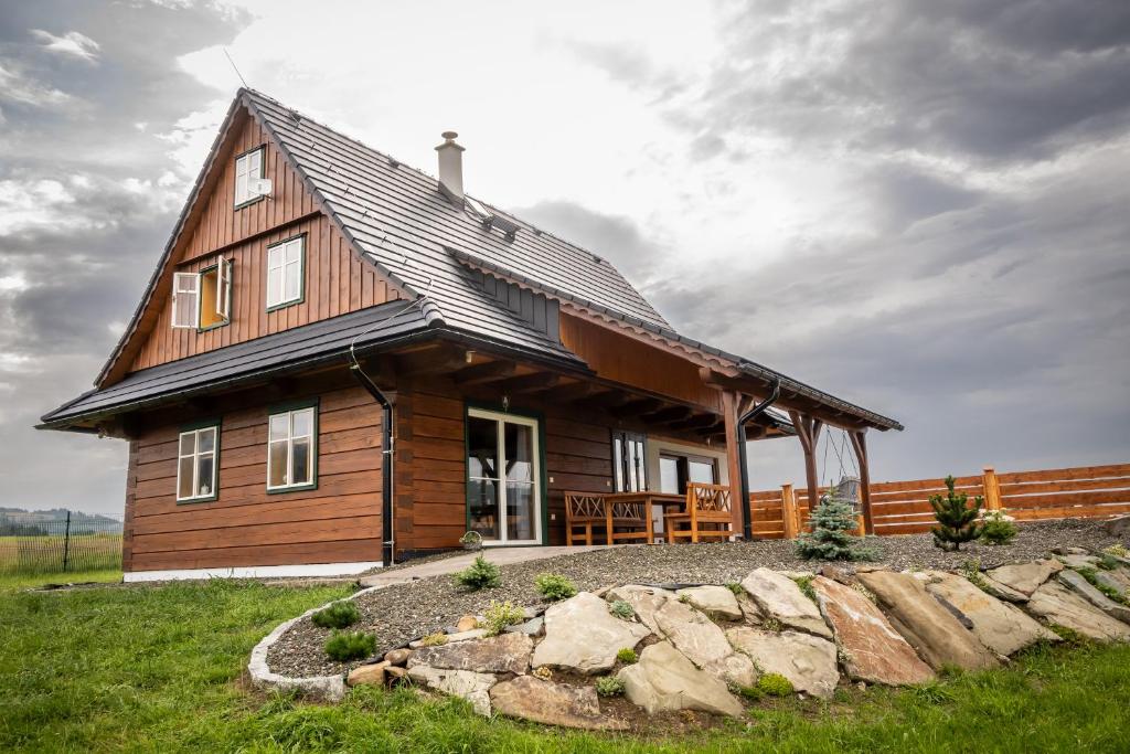 a large wooden house on a grassy field at Chalupa JaRo in Bukovec