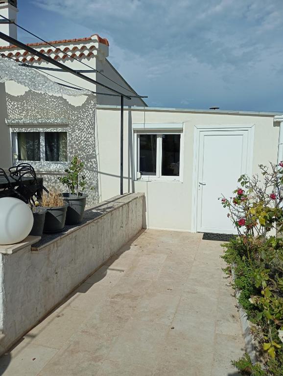a white garage with a white door and some plants at Appartement dans Villa à marignane in Marignane
