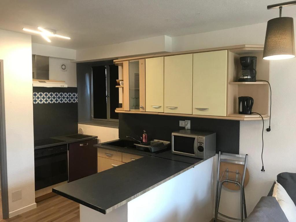 a kitchen with white cabinets and a counter top at Le gite 3 - Le Château du Lichtenberg in Sélestat