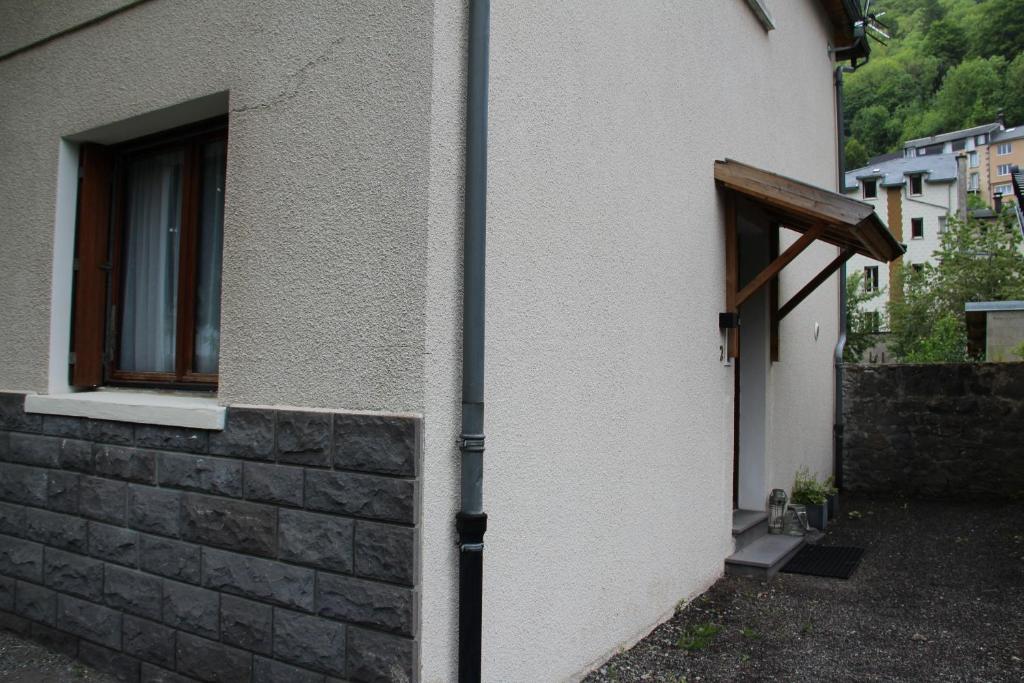 une porte menant à un bâtiment avec une fenêtre dans l'établissement Les Cimes 2, à Mont-Dore