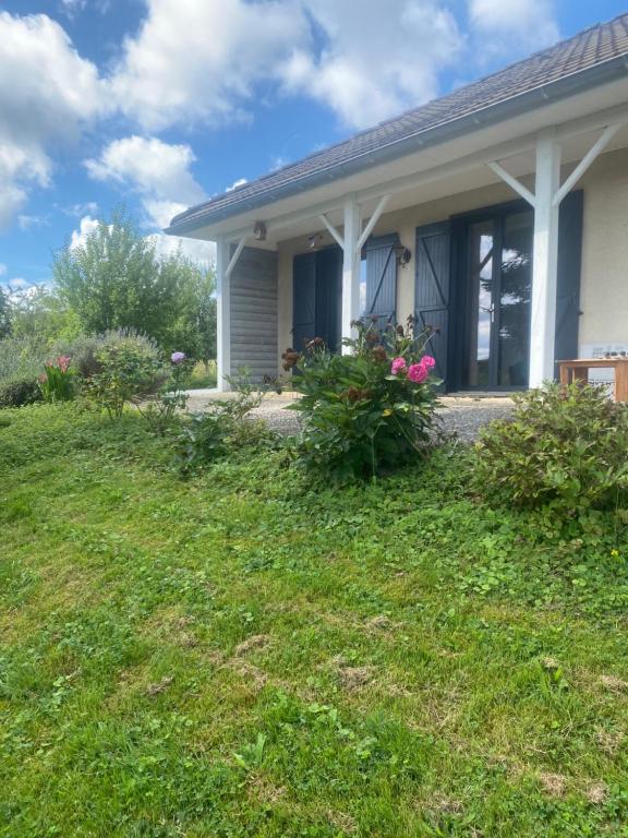 une maison avec quelques fleurs dans la cour dans l'établissement Logement indépendant au calme avec terrasse, à Mazerolles-le-Salin