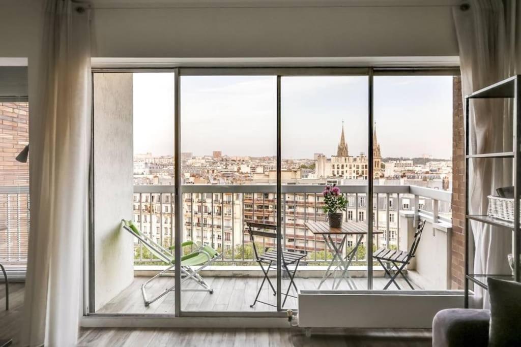 Cette chambre dispose d'un balcon offrant une vue sur la ville. dans l'établissement Studio Avec vue Panoramique Paris 11, à Paris