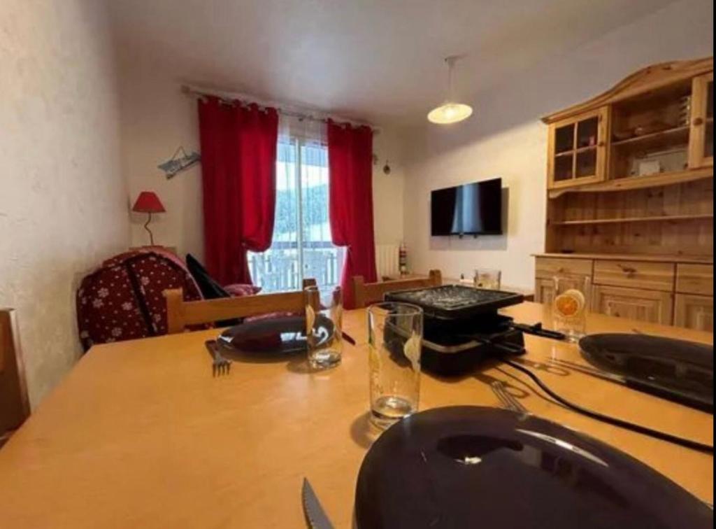 - un salon avec une table en bois et une salle à manger dans l'établissement Super Dévoluy résidence Les Issarts - Appart - 4 pers, à Saint-Étienne-en-Dévoluy