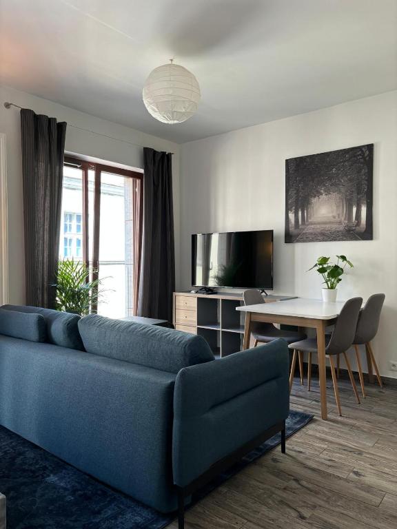 Una sala de estar con un sofá azul y una mesa. en Modern Studio in Old Town, en Poznan