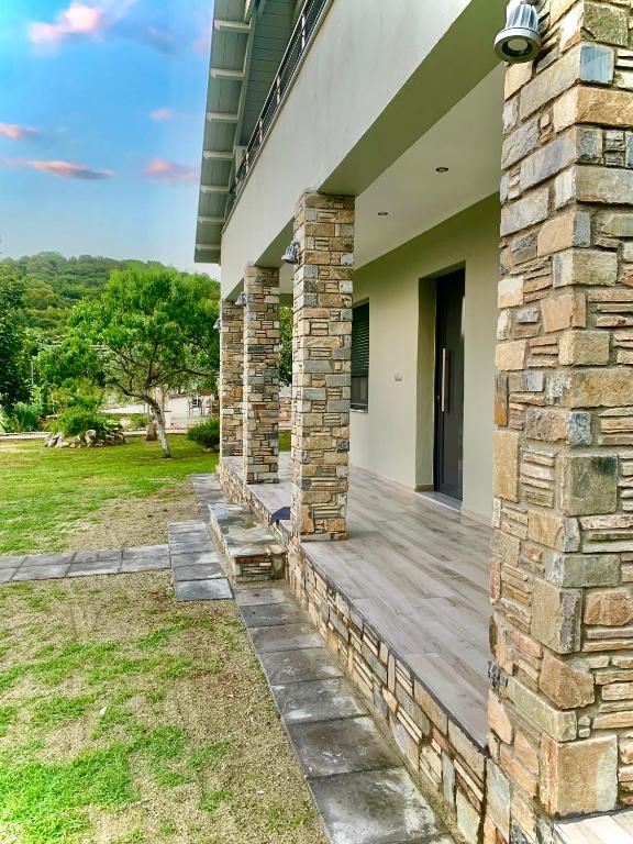 a porch of a house with a stone wall at Coastal vista retreat 2 in Neos Panteleimonas
