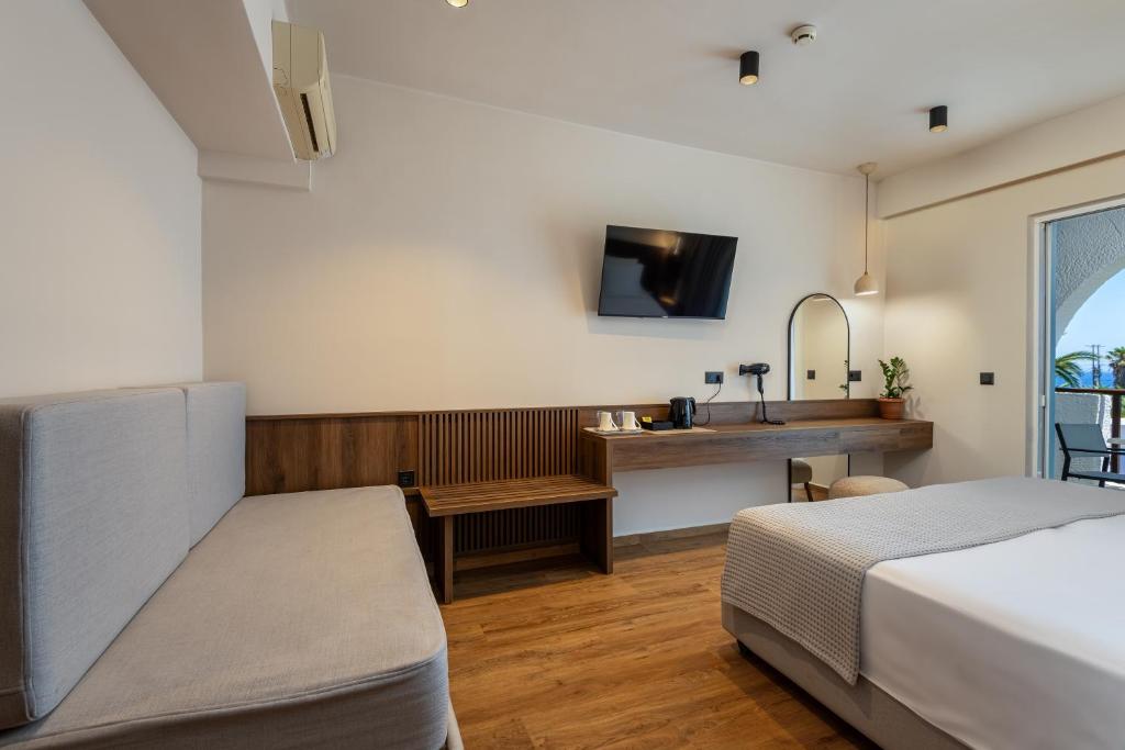 a bedroom with a bed and a desk with a sink at Kalimera Mare in Kardamaina