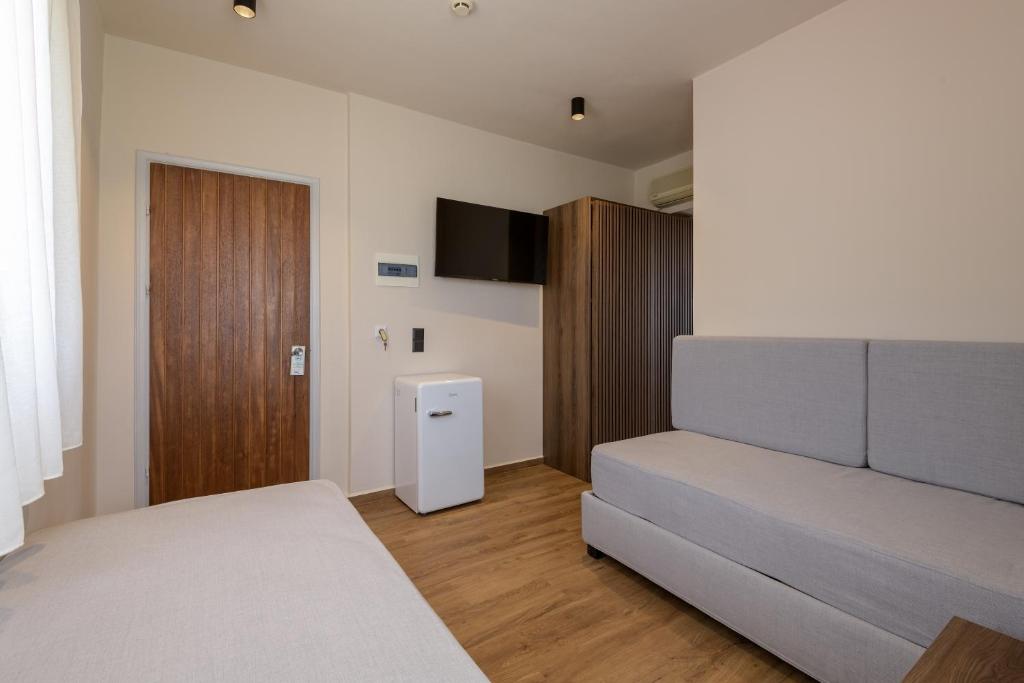a bedroom with a bed and a television in it at Kalimera Mare in Kardamaina