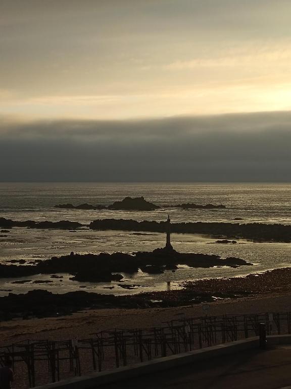 a lighthouse in the ocean on a beach at Cachinnans Hostel & apartaments in Vila do Conde