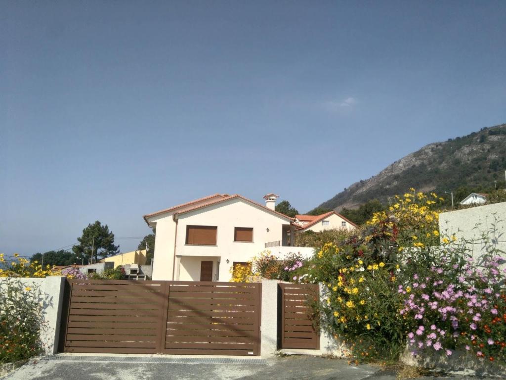 a house with a wooden fence and some flowers at ROOMS PEREGRINOS A Casa Alicia in Rosal
