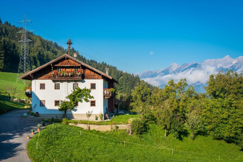 a house on a hill with mountains in the background at Bauernhaus in Kolsassberg