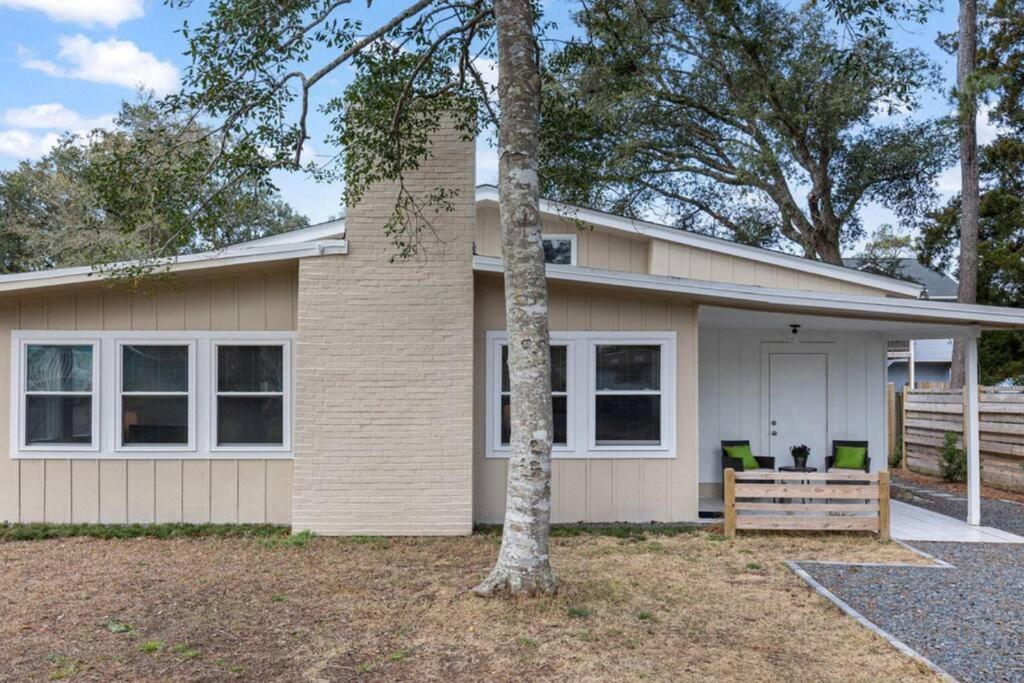 una casa con un árbol delante en Charming 1960s Cottage, 5 Min Walk to Beach and Shops, en Oak Island