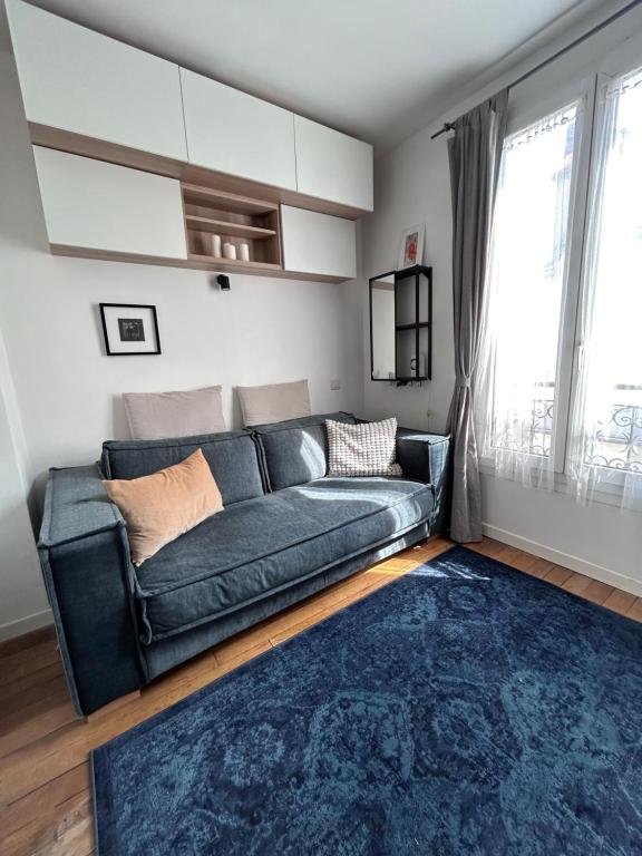 - un salon avec un canapé et un tapis bleu dans l'établissement Charmante studette Paris 5e, à Paris