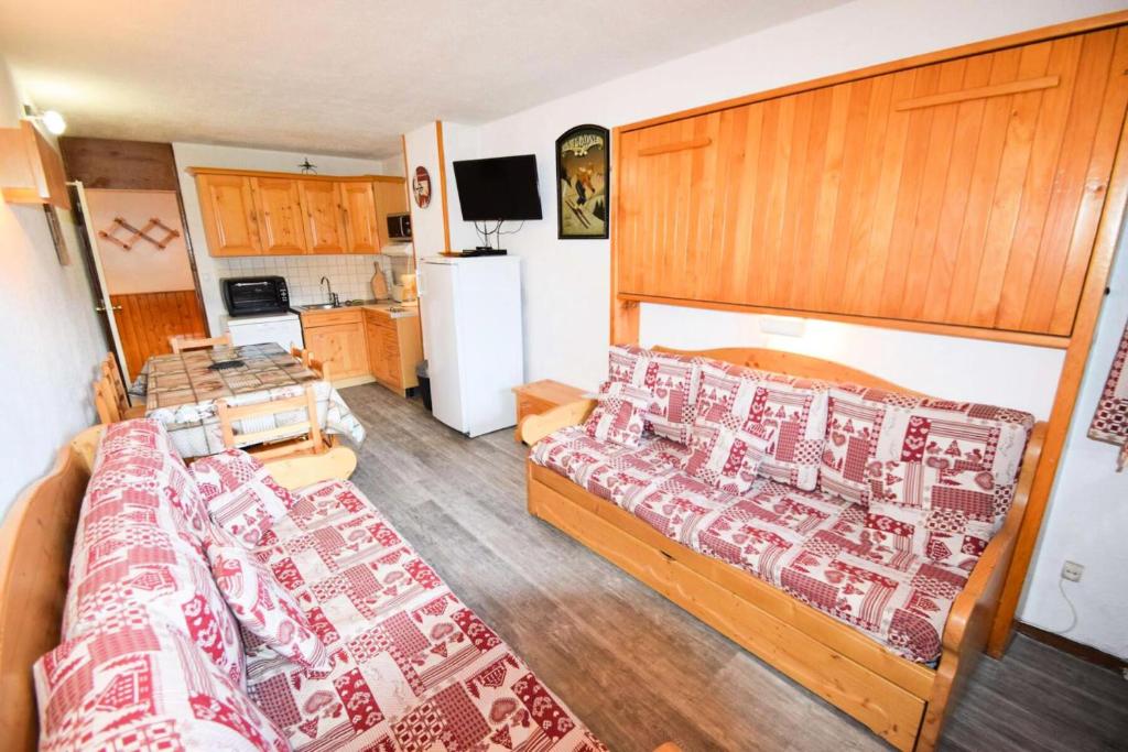 une chambre avec un grand lit et une cuisine dans l'établissement Résidence Le Plein Sud Centre - 2 Pièces 5 pers - Résidence Le Plein Sud - PLAGNE CENTRE MAE-6014, à Aime La Plagne