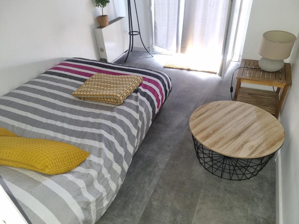 une chambre avec un lit, une table et une fenêtre dans l'établissement Studio indépendant et Jardin 600m2 Terrasse, à Carbon-Blanc